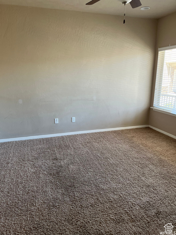 Carpeted empty room featuring ceiling fan