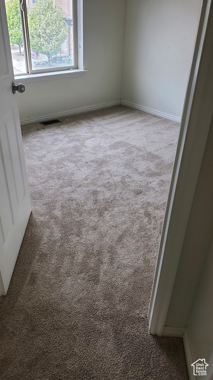 Carpeted spare room with baseboards and visible vents
