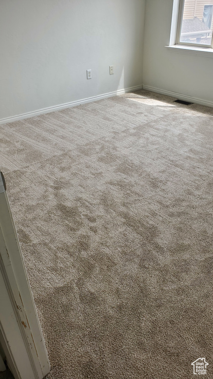 Carpeted spare room with baseboards and visible vents