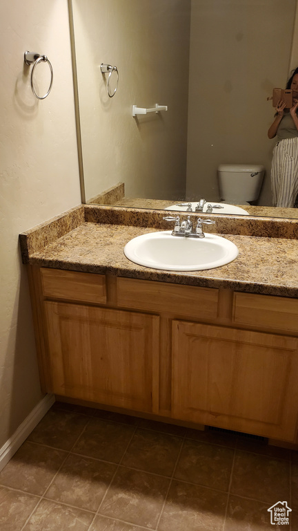 Bathroom featuring tile patterned floors, vanity, and toilet