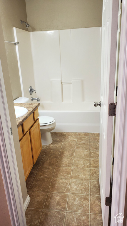 Full bathroom featuring bathing tub / shower combination, toilet, vanity, and tile patterned floors