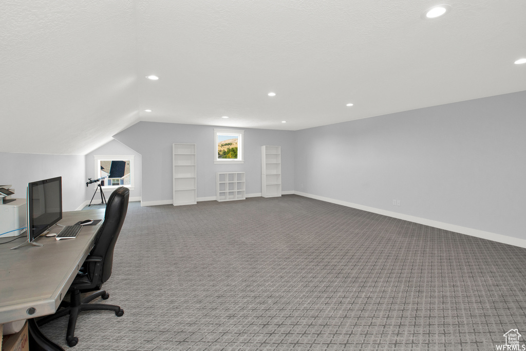 Home office featuring vaulted ceiling and carpet flooring