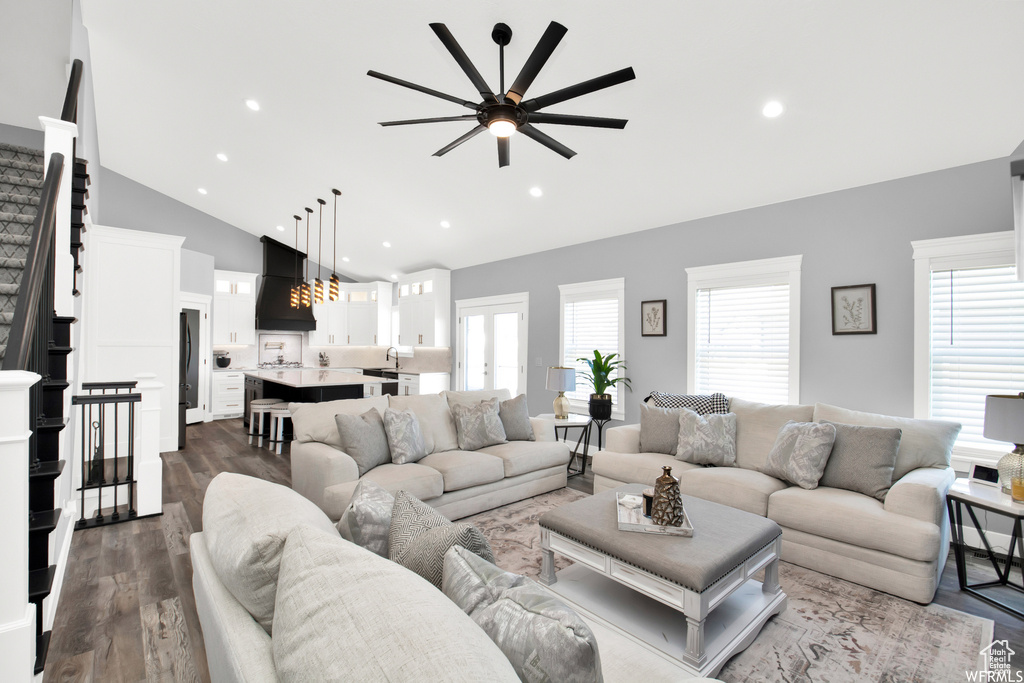 Living room with ceiling fan, sink, hardwood / wood-style flooring, and lofted ceiling