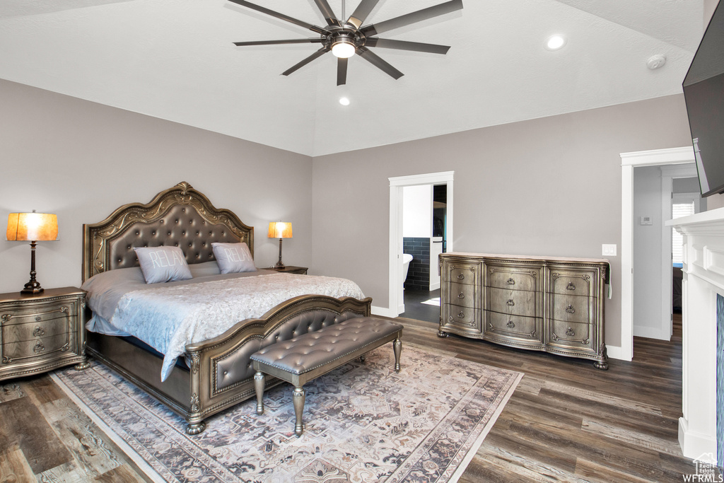 Bedroom featuring ensuite bath, ceiling fan, hardwood / wood-style flooring, and lofted ceiling