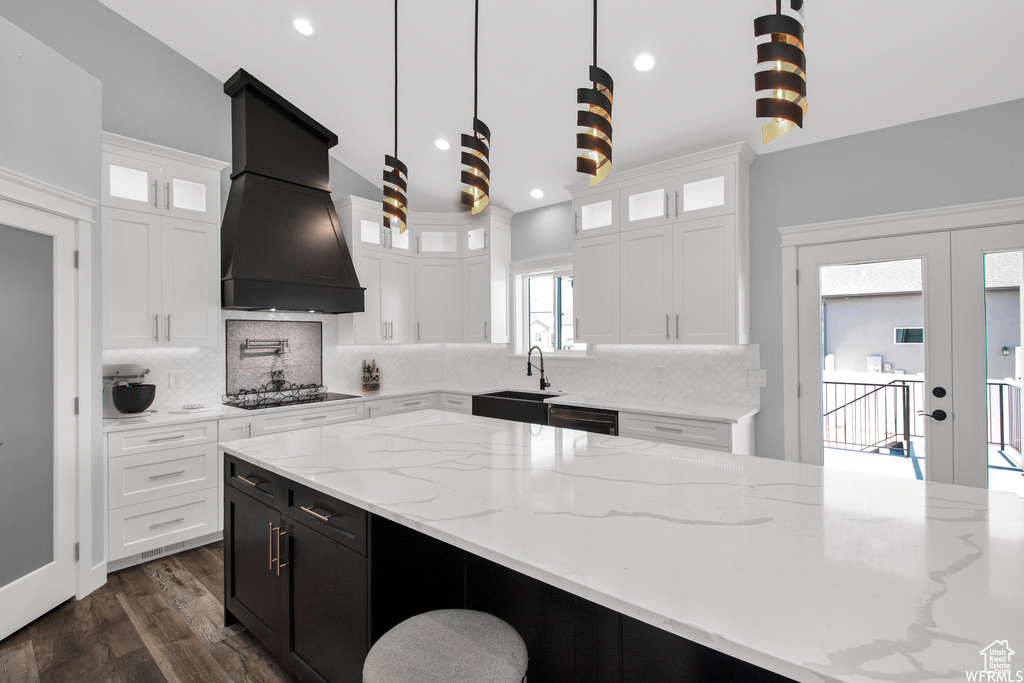 Kitchen with tasteful backsplash, french doors, dark hardwood / wood-style floors, dishwasher, and custom range hood