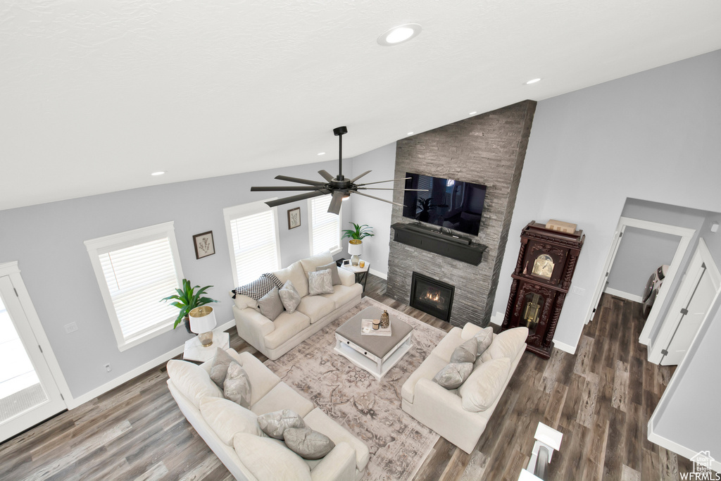 Living room with a fireplace, hardwood / wood-style flooring, high vaulted ceiling, and ceiling fan