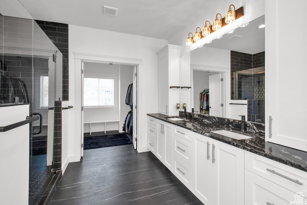 Interior space featuring sink, dark hardwood / wood-style floors, dark stone counters, and white cabinets