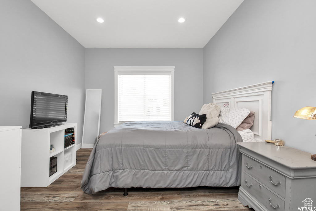 Bedroom featuring dark wood-type flooring and lofted ceiling