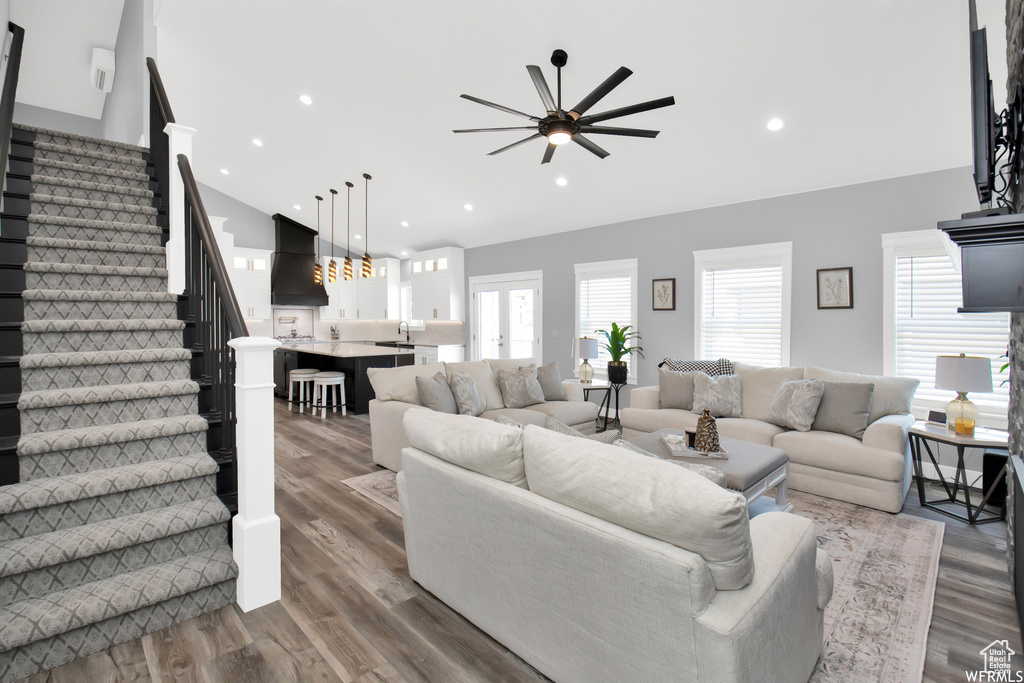 Living room with a healthy amount of sunlight, light wood-type flooring, and ceiling fan