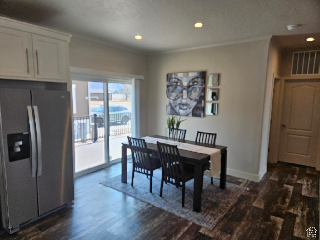 Dining space featuring crown molding and dark hardwood / wood-style flooring