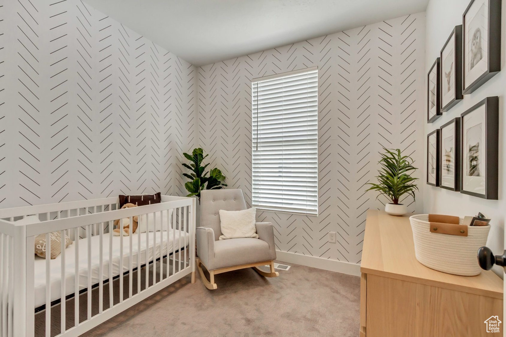 Bedroom featuring carpet flooring and a nursery area