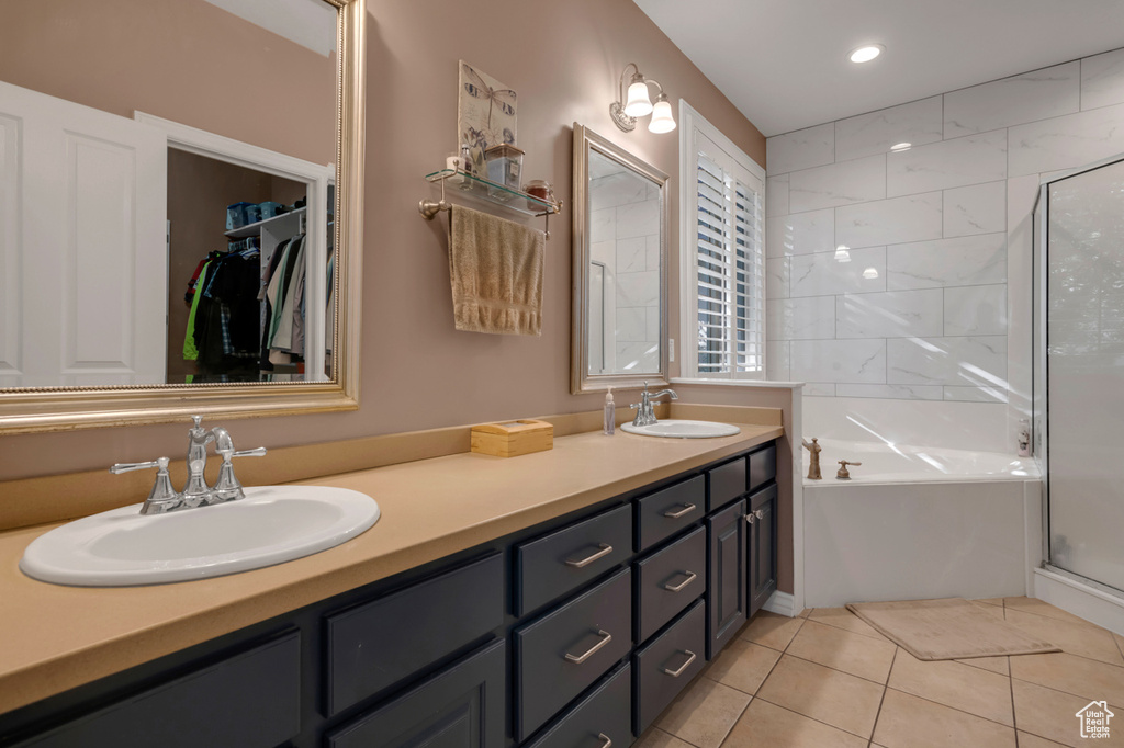 Bathroom featuring dual vanity, tile patterned flooring, and separate shower and tub