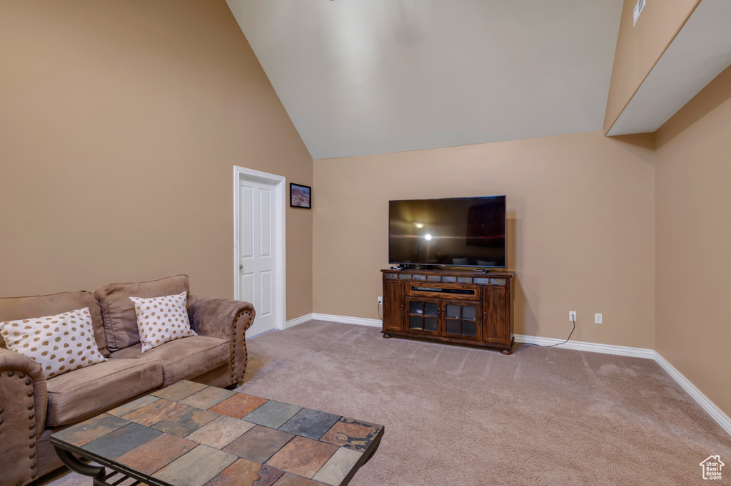 Living room with carpet and high vaulted ceiling