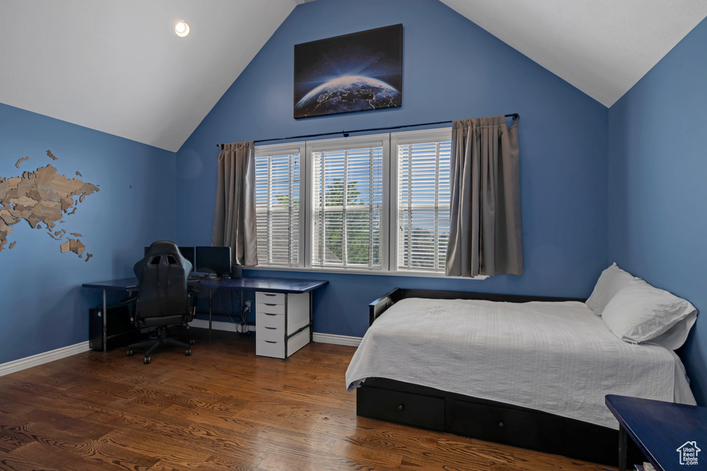 Bedroom with lofted ceiling and hardwood / wood-style floors