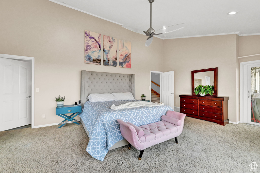 Bedroom with a towering ceiling, ceiling fan, ornamental molding, and light colored carpet