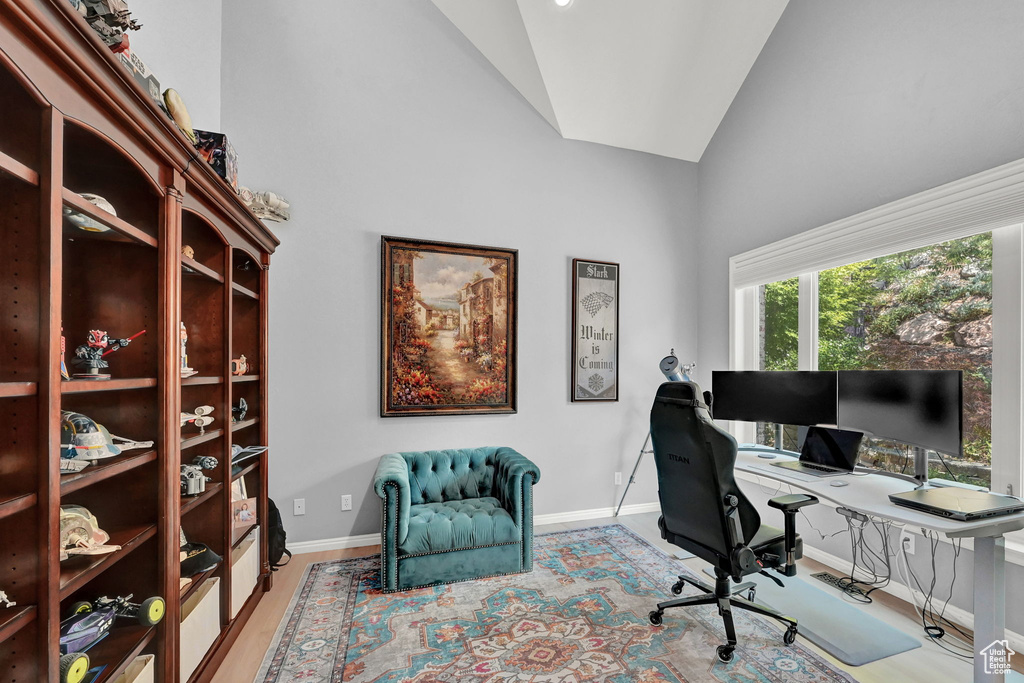 Office featuring high vaulted ceiling and light hardwood / wood-style flooring