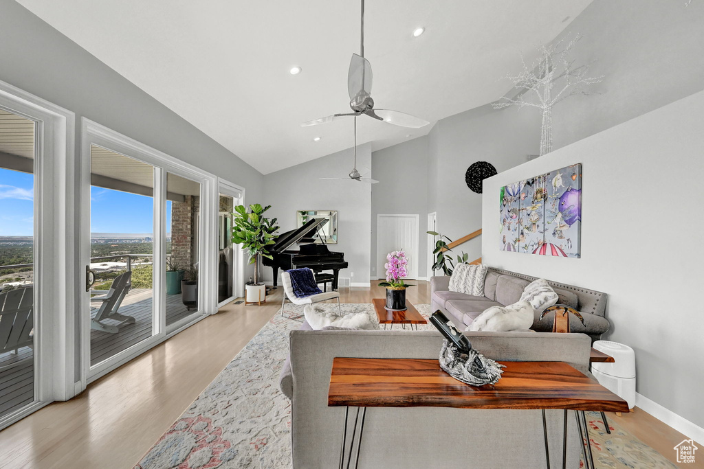 Living room featuring light hardwood / wood-style flooring, high vaulted ceiling, and ceiling fan