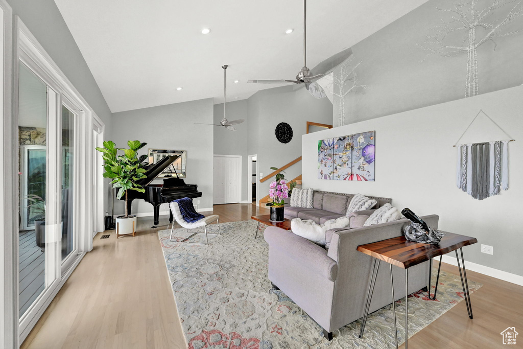 Living room featuring ceiling fan, light hardwood / wood-style flooring, and high vaulted ceiling