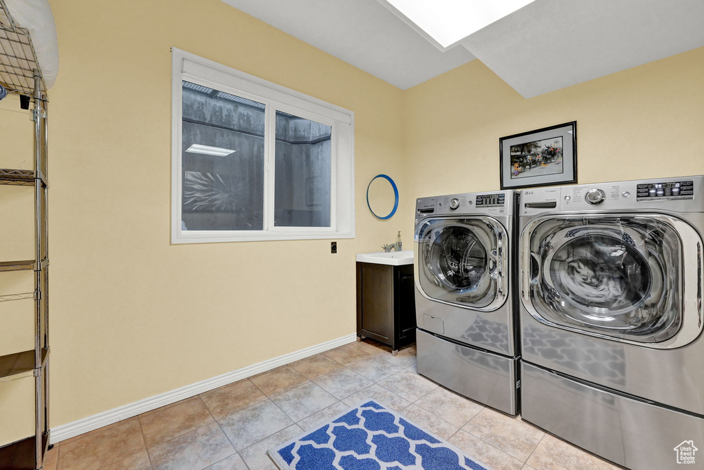 Laundry room with separate washer and dryer, sink, and light tile patterned floors