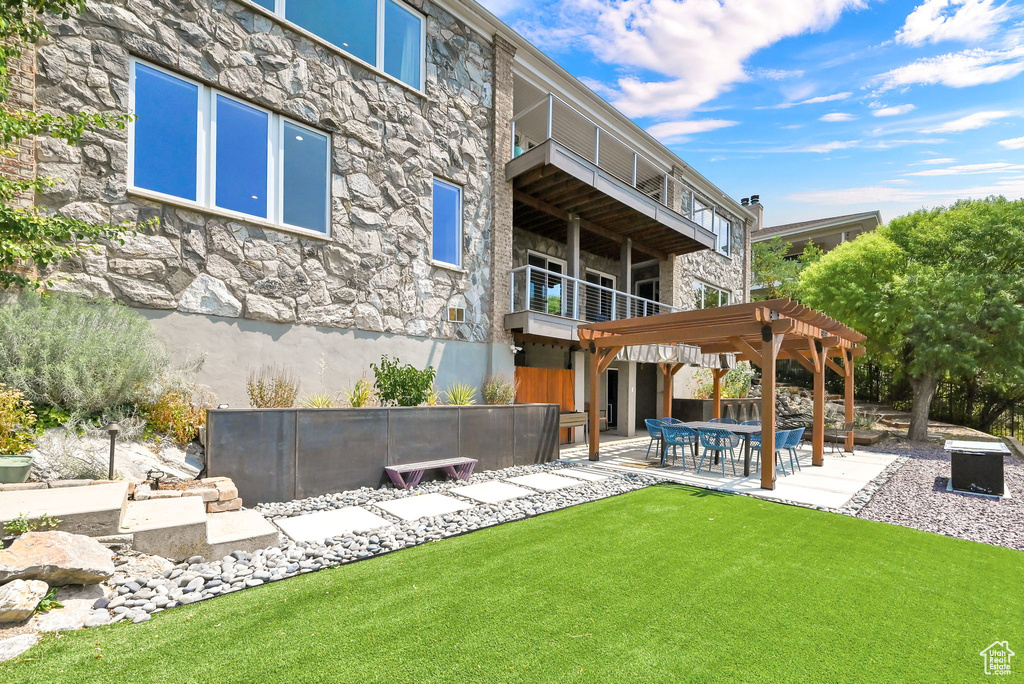 Back of property with a patio, a balcony, and a pergola