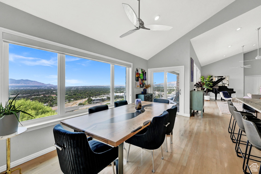 Dining space with plenty of natural light, light wood-type flooring, ceiling fan, and vaulted ceiling