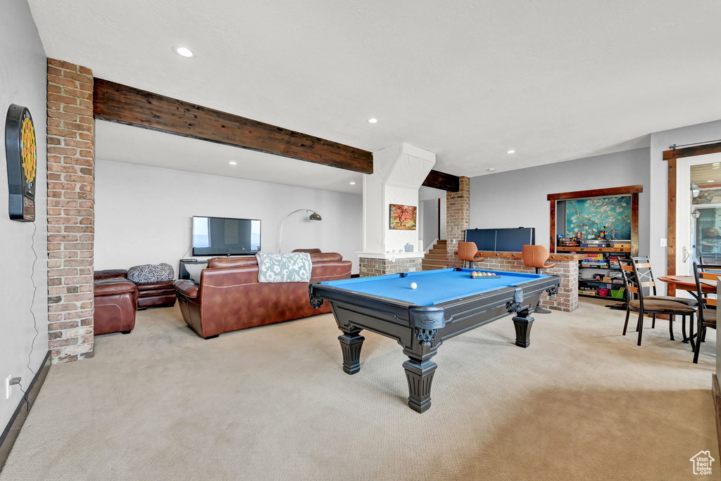 Playroom with pool table, light carpet, beam ceiling, and brick wall