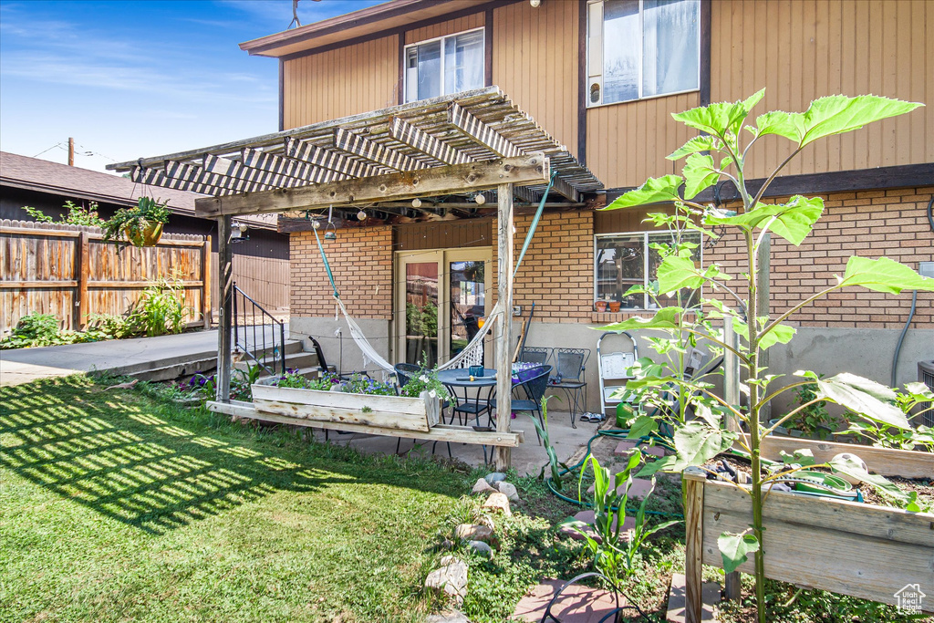 Back of house featuring a patio, a lawn, and a pergola