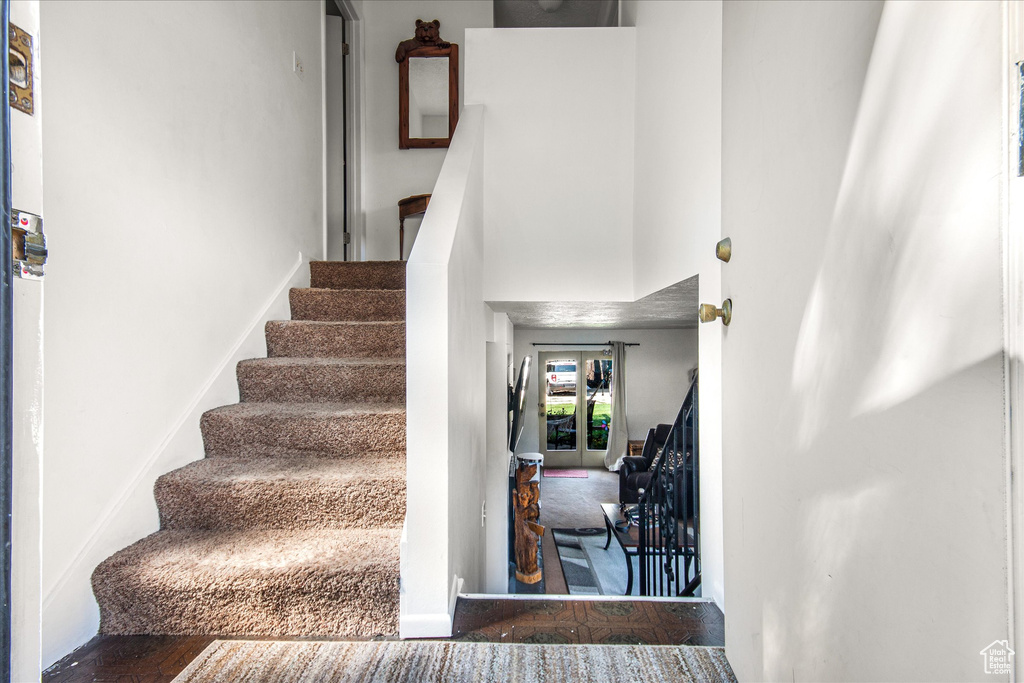 Stairway with hardwood / wood-style floors and a high ceiling