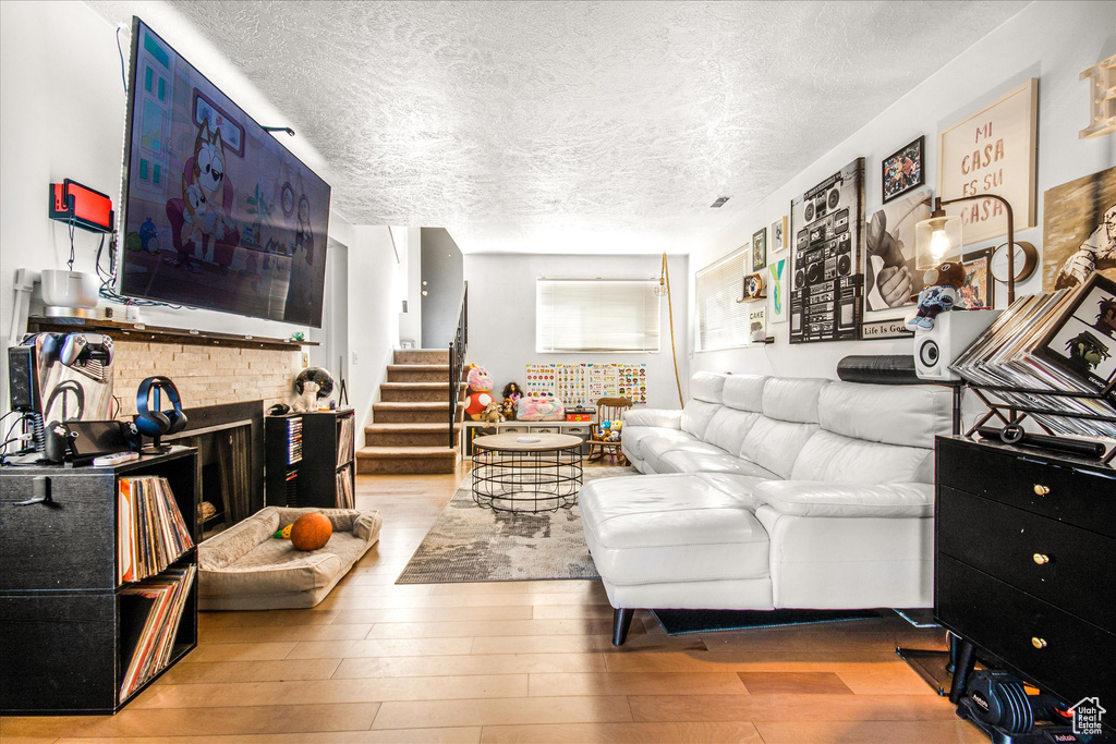 Living room featuring light hardwood / wood-style flooring and a textured ceiling