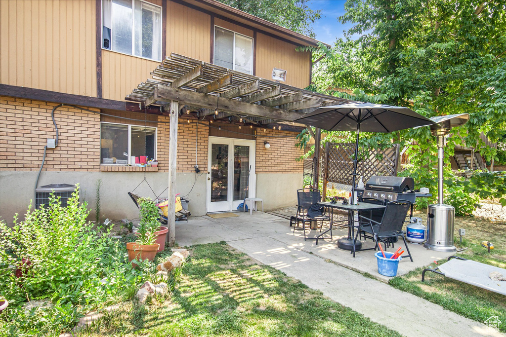 Rear view of property with a patio, central AC unit, and a pergola