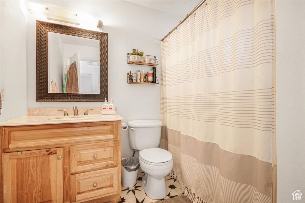 Bathroom with vanity, toilet, and tile patterned flooring