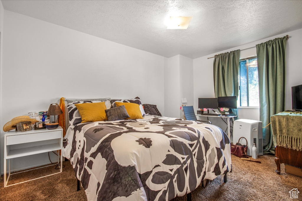 Carpeted bedroom featuring a textured ceiling