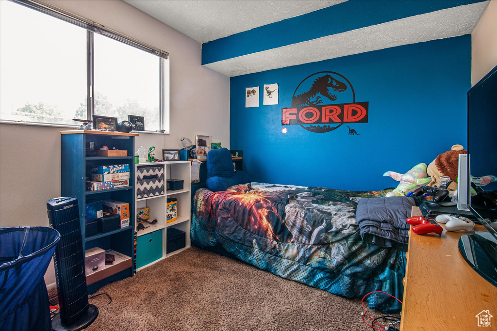 Bedroom featuring carpet and a textured ceiling