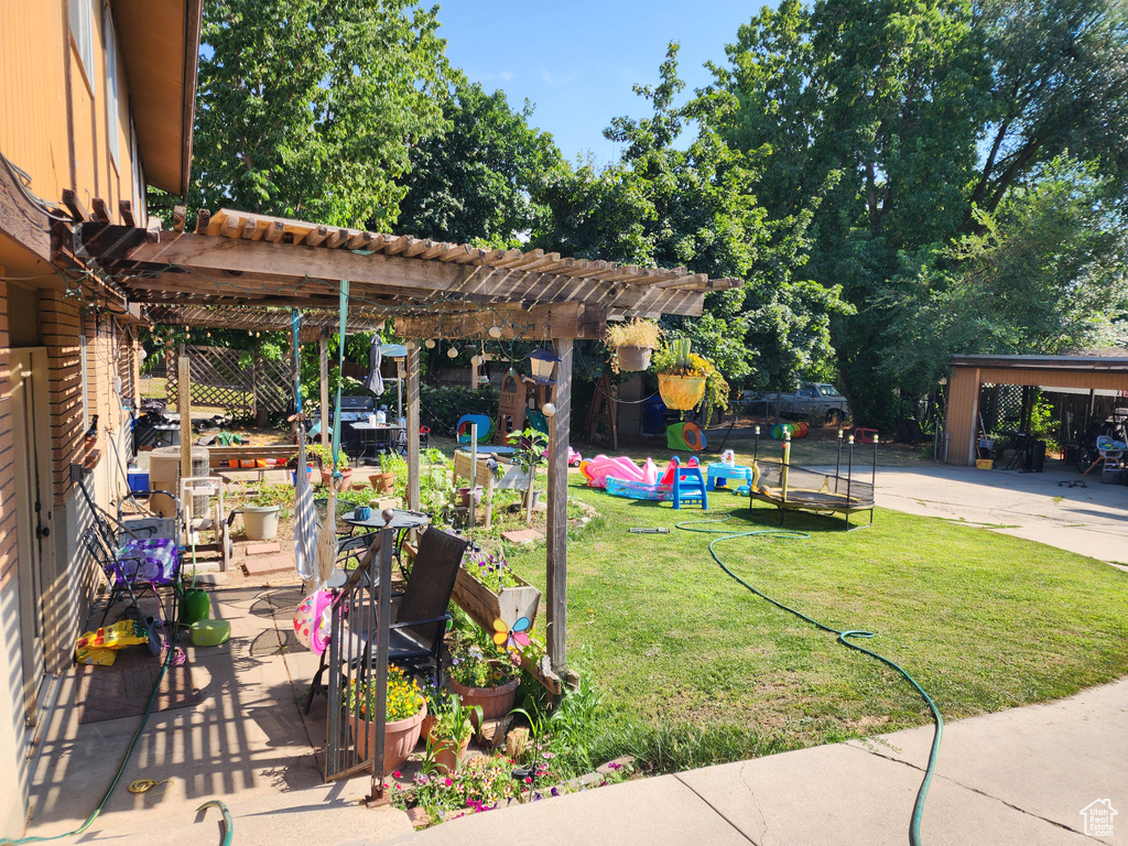 View of yard with a patio, a trampoline, and a pergola