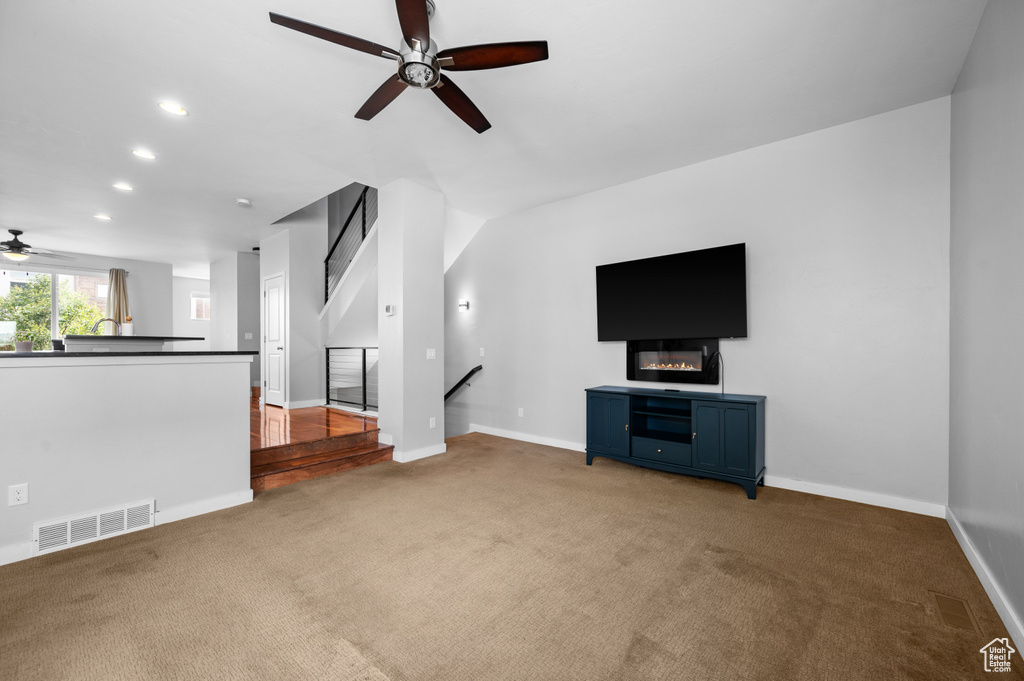 Unfurnished living room with light hardwood / wood-style floors and ceiling fan