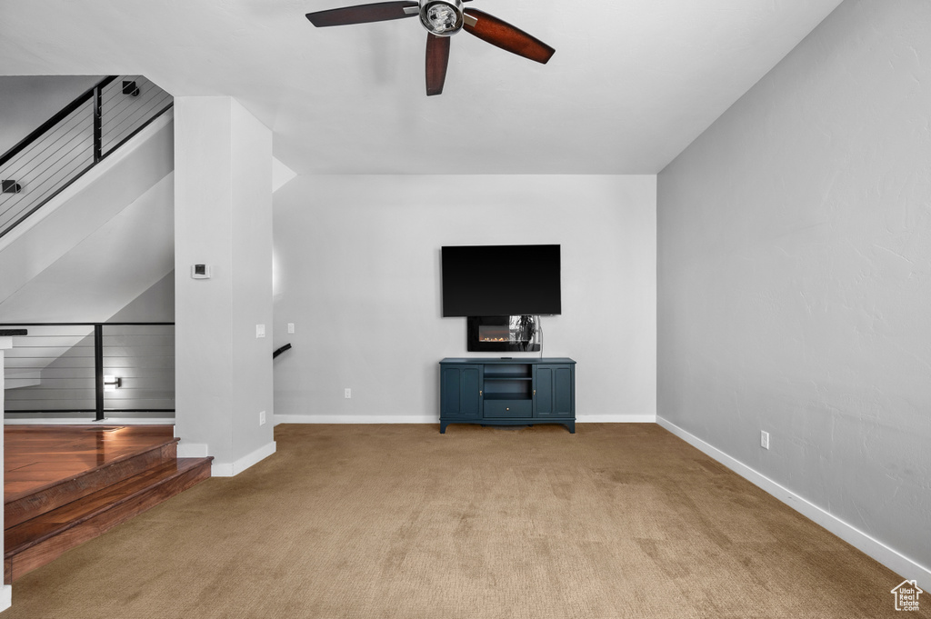 Unfurnished living room featuring light colored carpet and ceiling fan