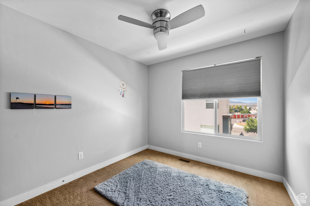 Carpeted empty room with ceiling fan