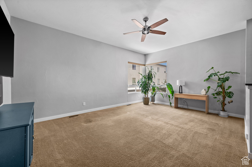 Unfurnished room featuring light colored carpet and ceiling fan