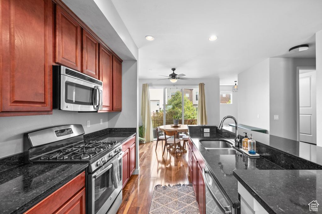 Kitchen featuring dark stone countertops, hardwood / wood-style flooring, and stainless steel appliances