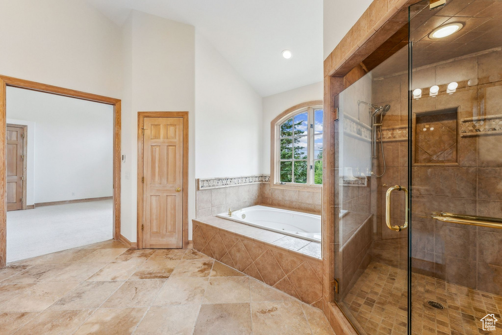 Bathroom featuring shower with separate bathtub, tile patterned floors, and high vaulted ceiling