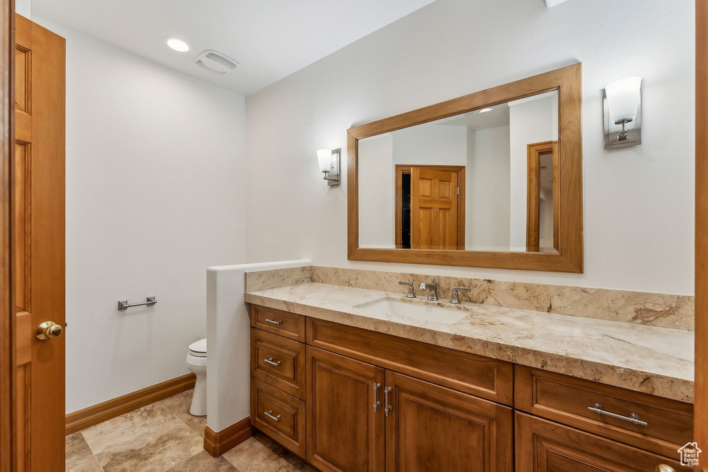 Bathroom featuring vanity, tile patterned flooring, and toilet