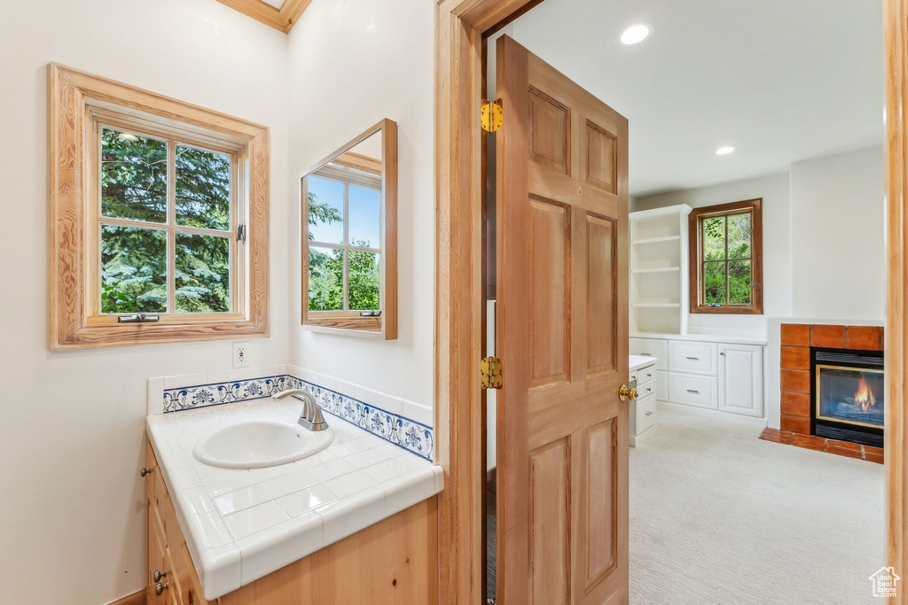 Bathroom with vanity and a tiled fireplace