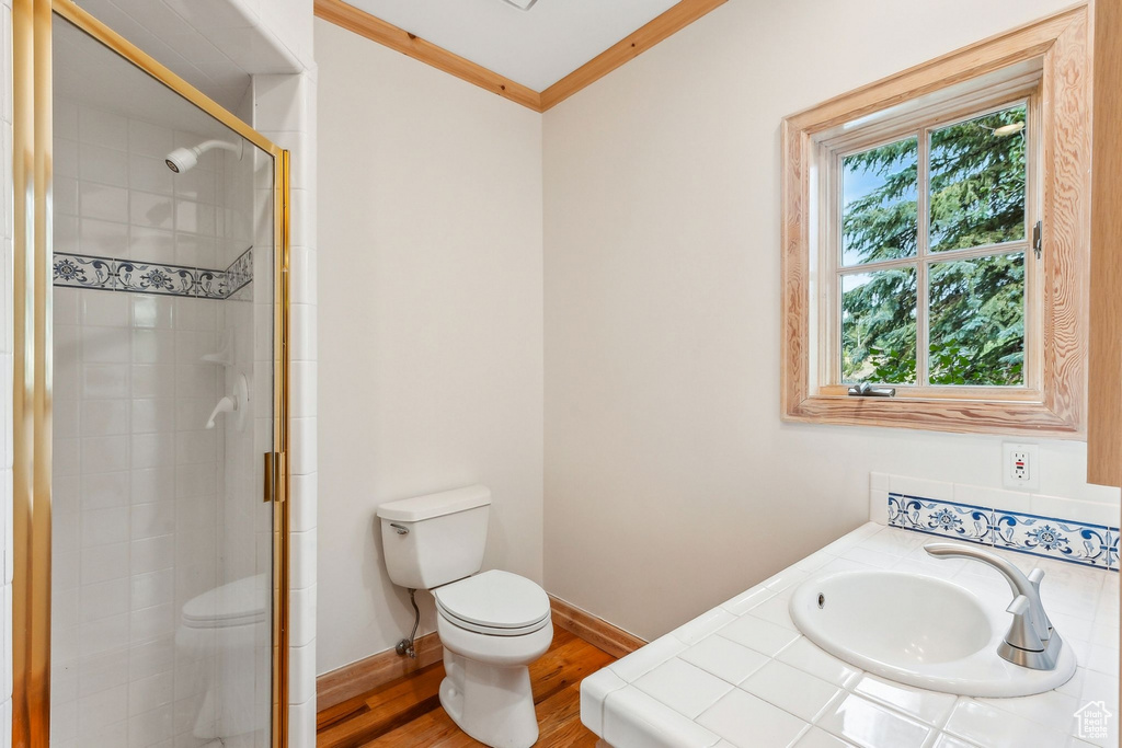 Bathroom featuring crown molding, an enclosed shower, toilet, hardwood / wood-style flooring, and sink