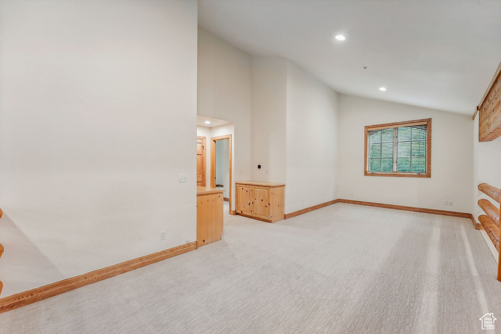 Interior space with high vaulted ceiling and light carpet