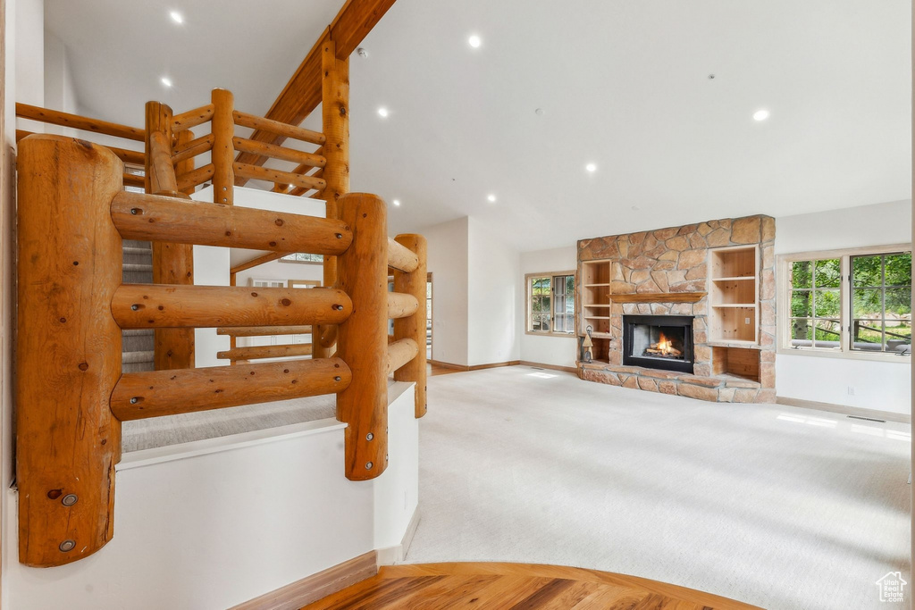 Interior space with a stone fireplace and carpet flooring