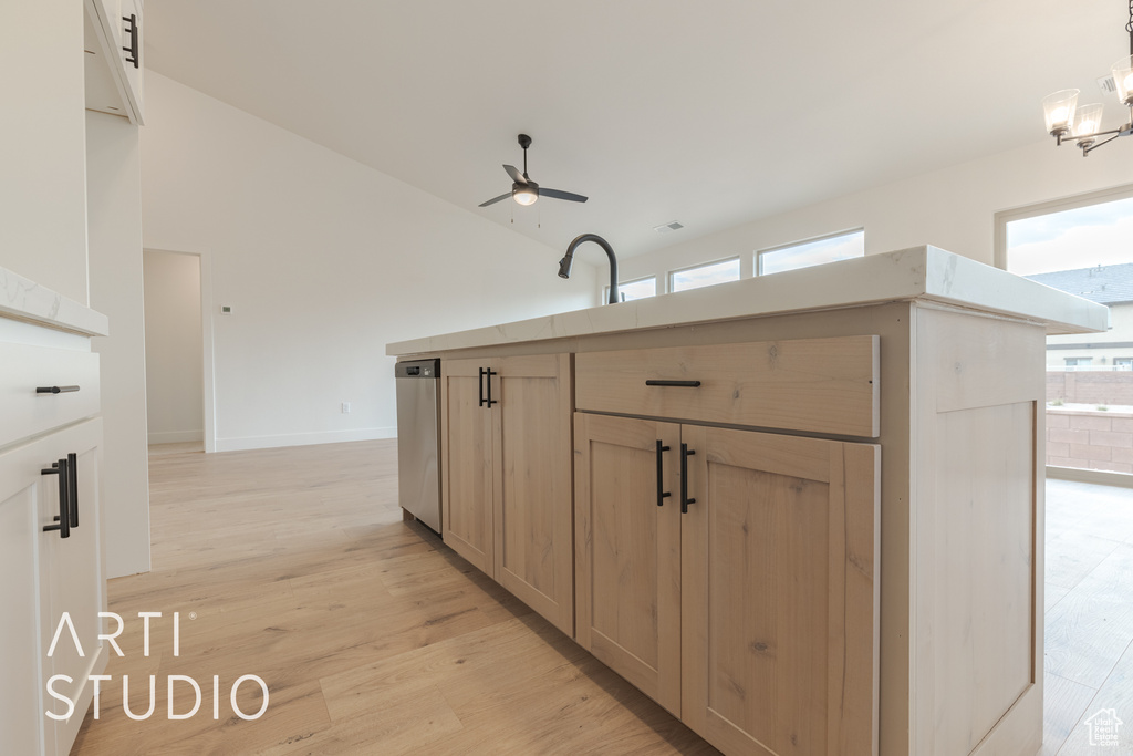 Kitchen with hanging light fixtures, ceiling fan with notable chandelier, light brown cabinets, dishwasher, and light hardwood / wood-style flooring