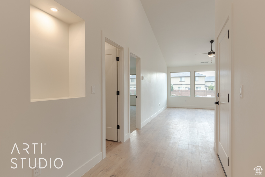 Hallway featuring light hardwood / wood-style floors and lofted ceiling