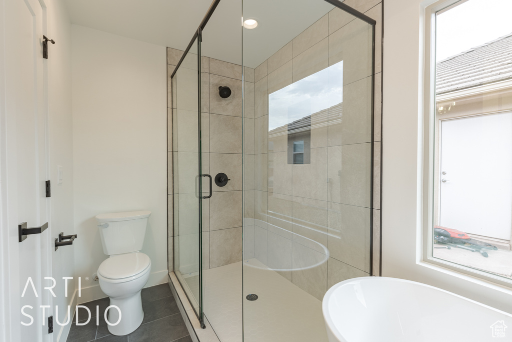 Bathroom with tile patterned floors, toilet, and an enclosed shower