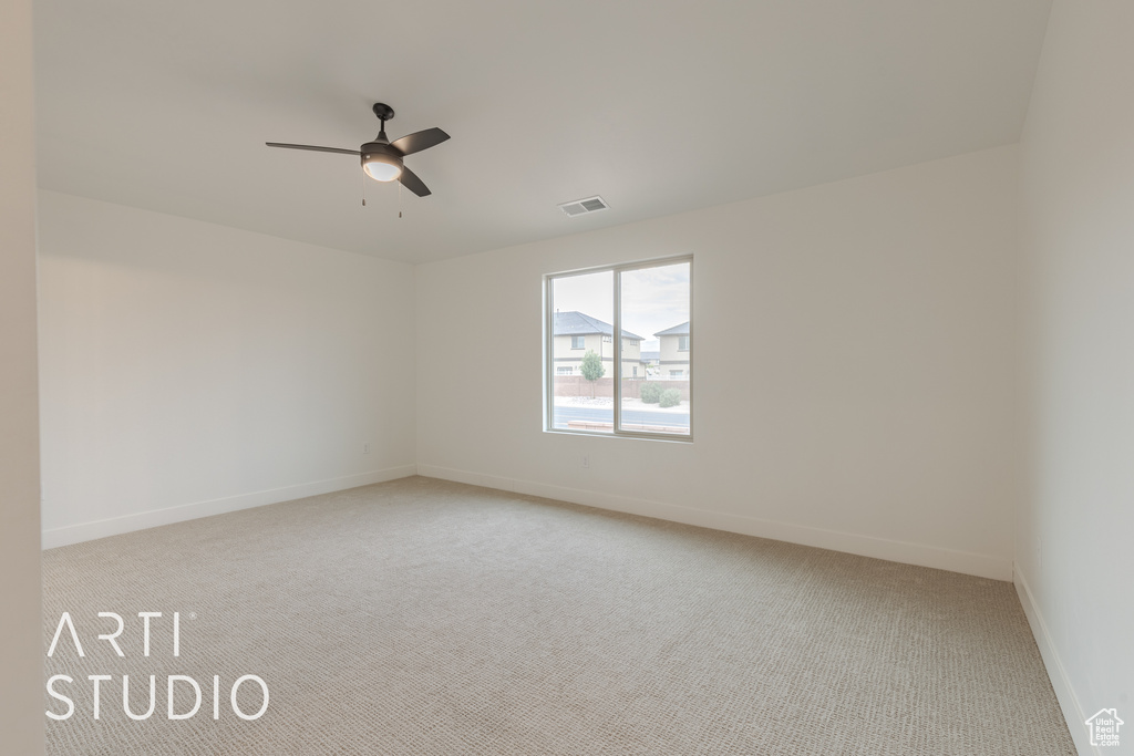 Carpeted empty room with ceiling fan