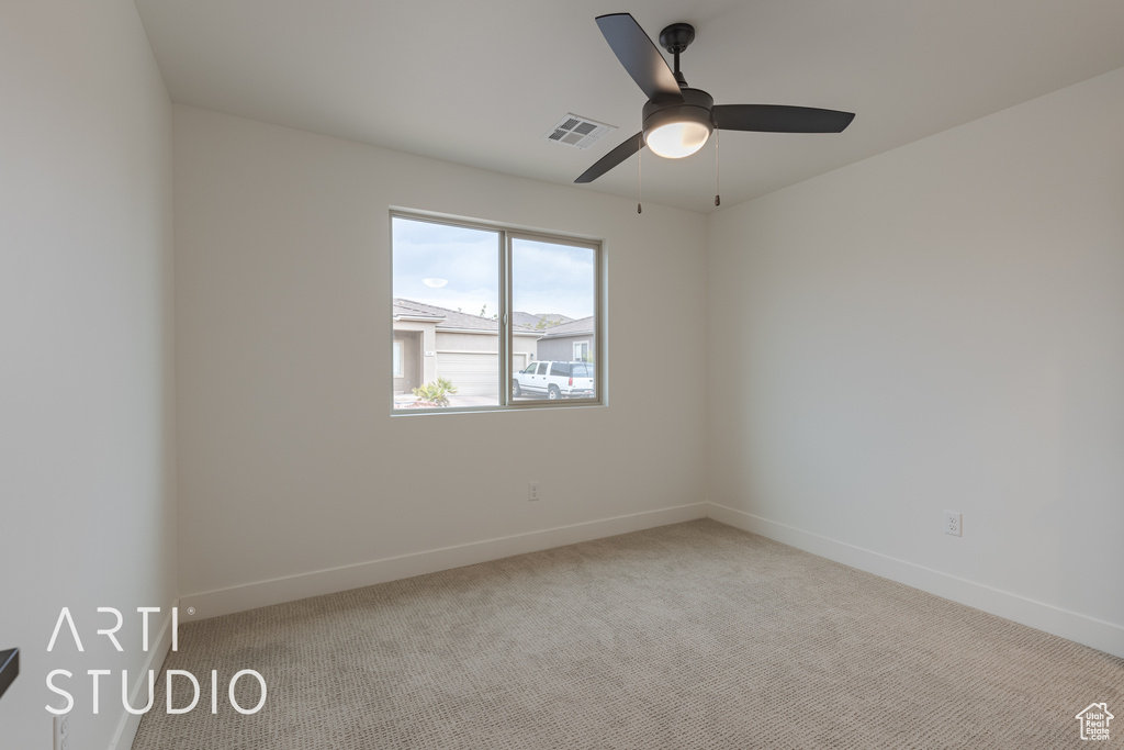 Carpeted spare room featuring ceiling fan